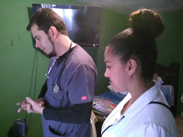 Ersiel junto con el Dr. Picado en visita comunitaria. Sus miradas expresan la compasión hacia sus pacientes